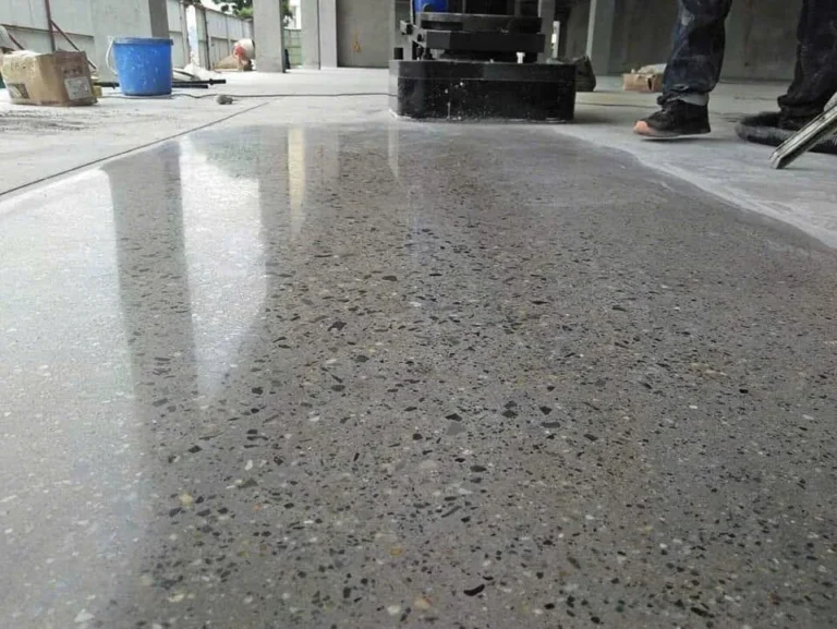 Máy mài đang xử lý sàn bê tông, phần đã mài bóng phản chiếu rõ